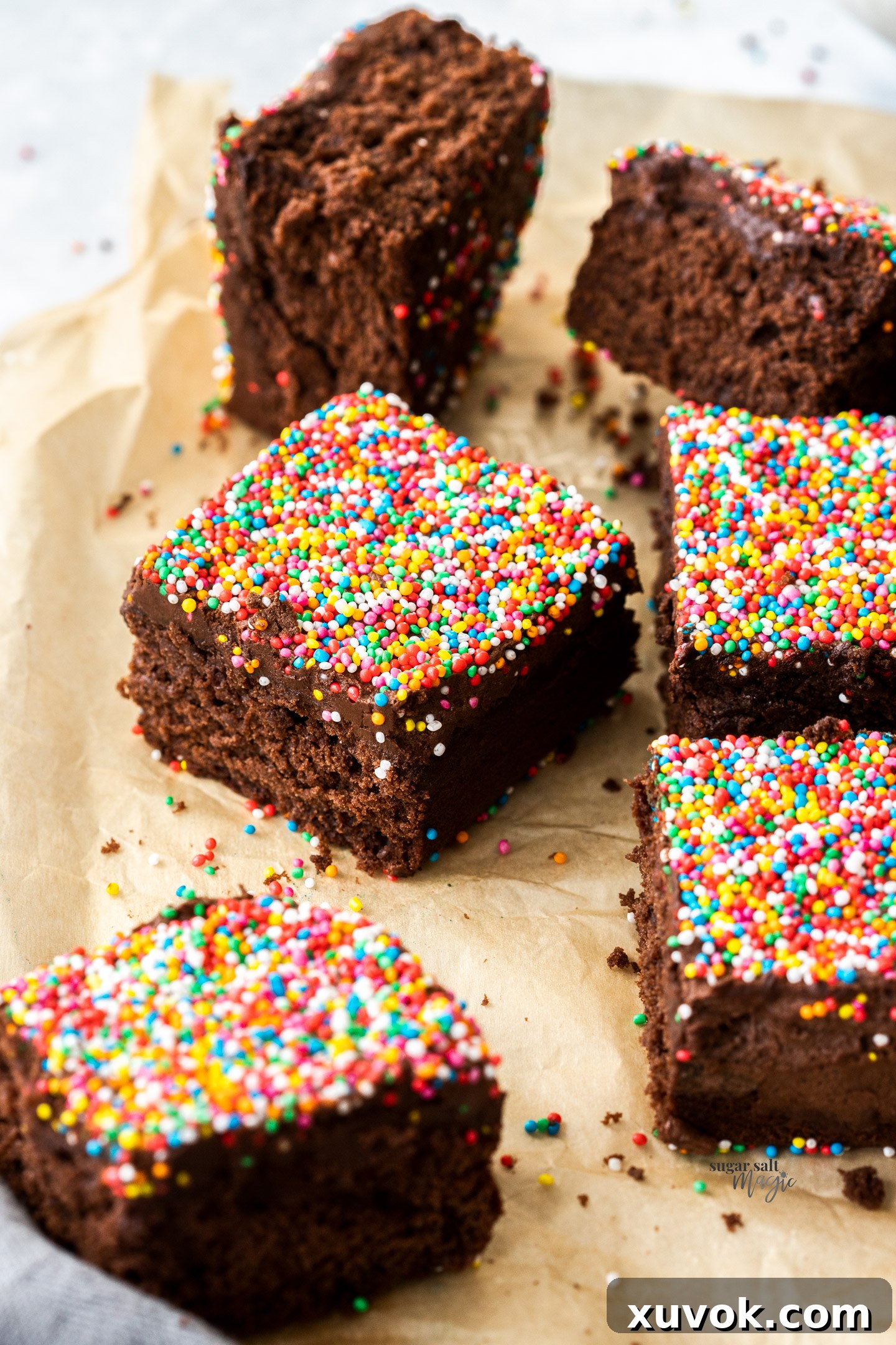 Squares of rich, fudgy chocolate cake, generously covered in colorful sprinkles, arranged enticingly.