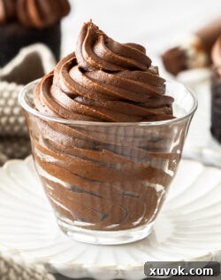 A closeup of a glass filled with fudge frosting.