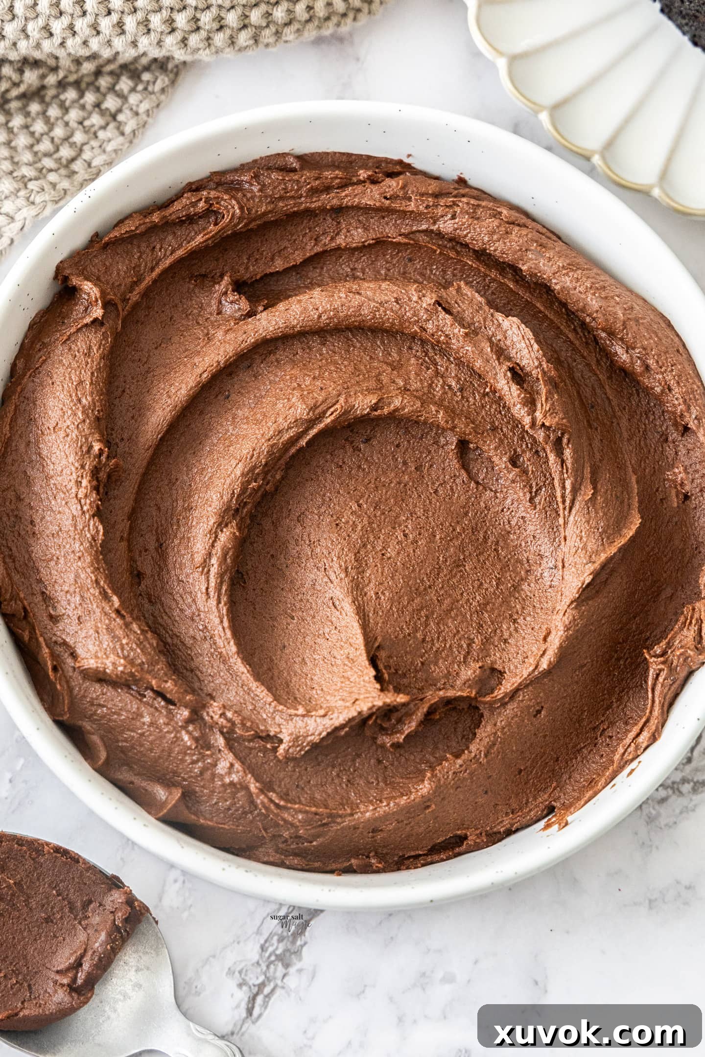 Beautiful swirls of chocolate fudge frosting artfully arranged in a bowl.