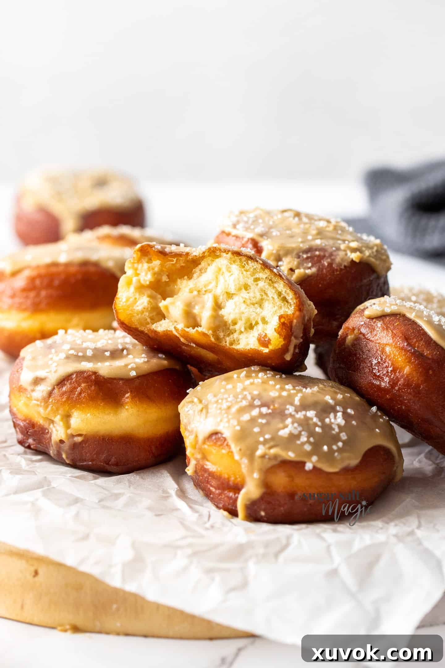 A fluffy caramel doughnut torn in half, revealing its incredibly soft, airy texture and a generous filling of creamy brown sugar custard.