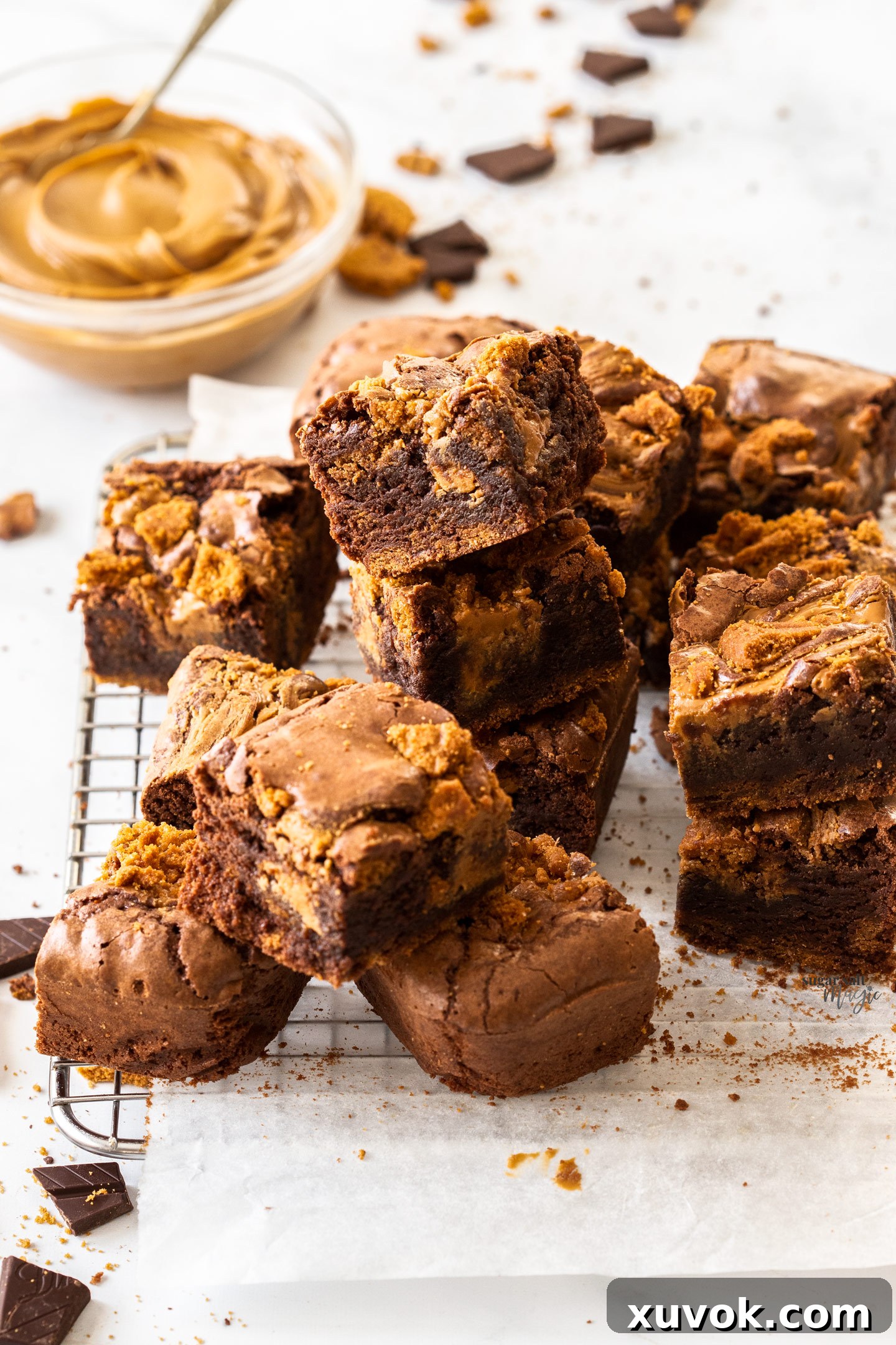 A batch of Biscoff brownies piled up on a wire rack, ready for serving.