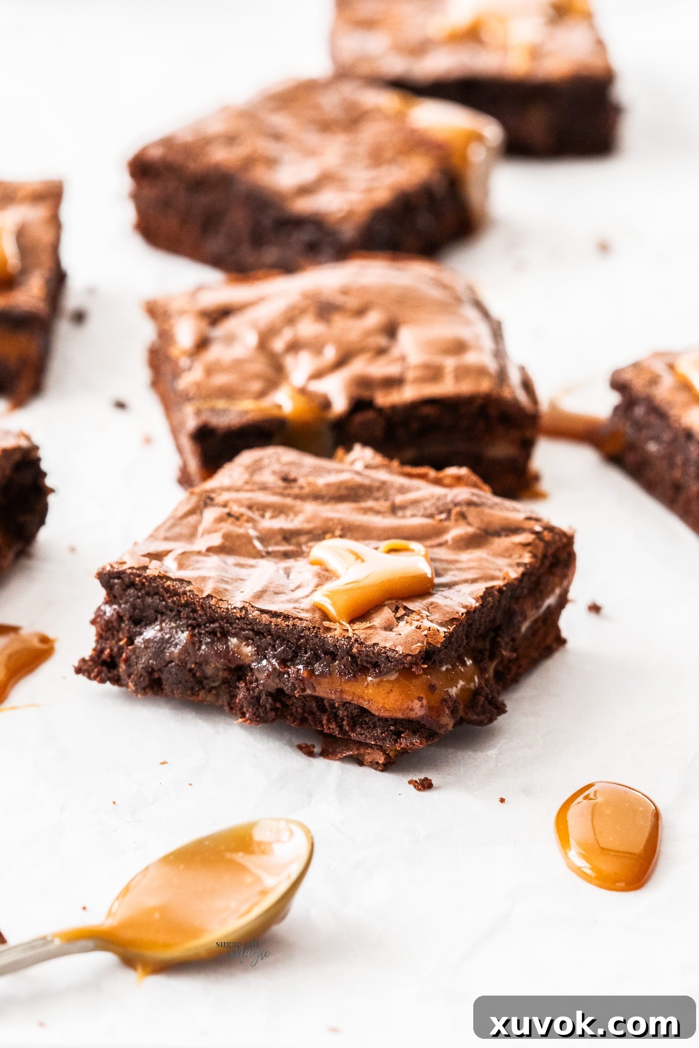 A single chocolate caramel brownie, perfectly sliced, with golden caramel oozing enticingly from the center.