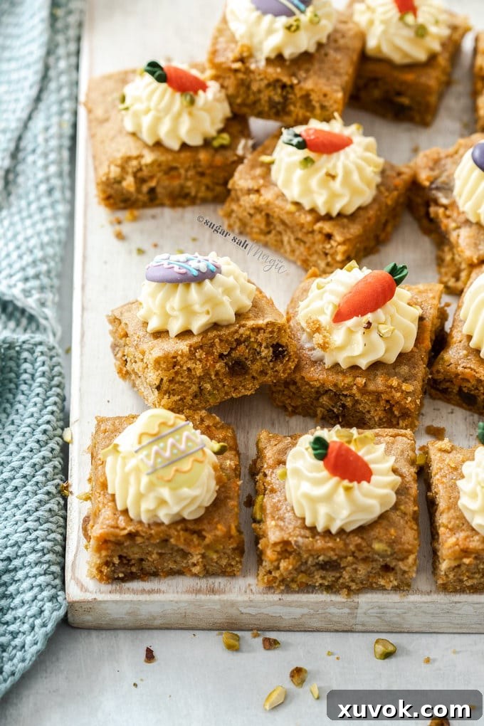 A batch of carrot cake bars topped with cream cheese frosting and royal icing Easter decorations