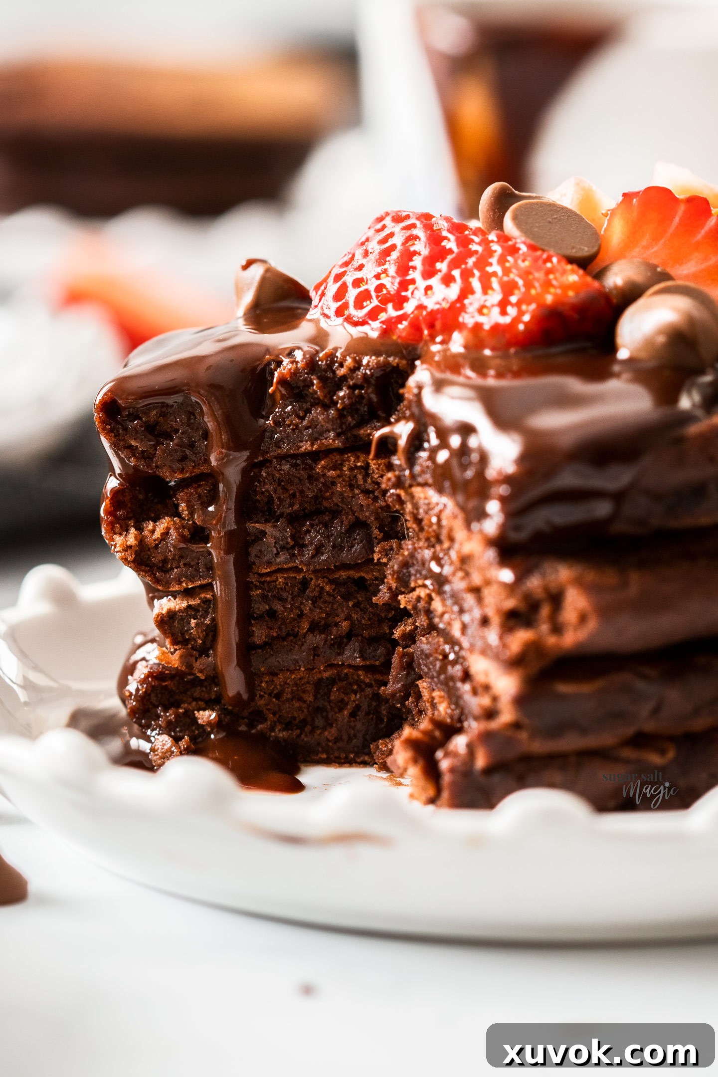 A stack of chocolate pancakes cut open to show the inside, revealing their thick, fluffy texture.