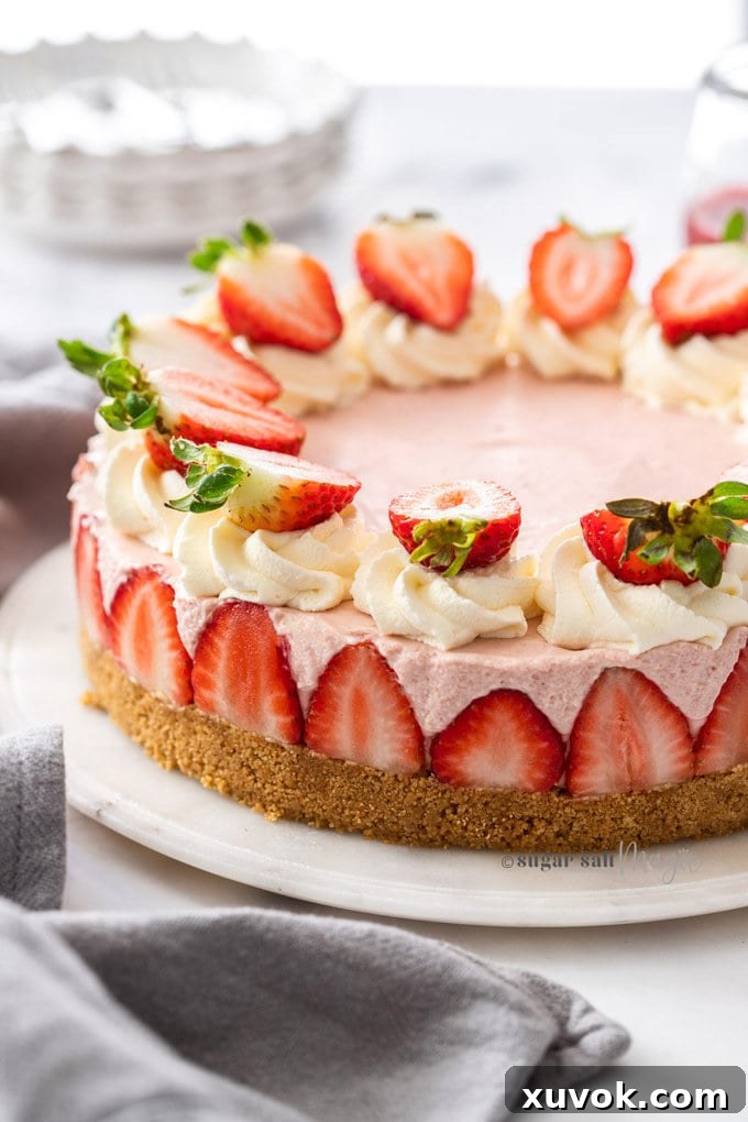 A pink cheesecake topped with strawberries on a marble background