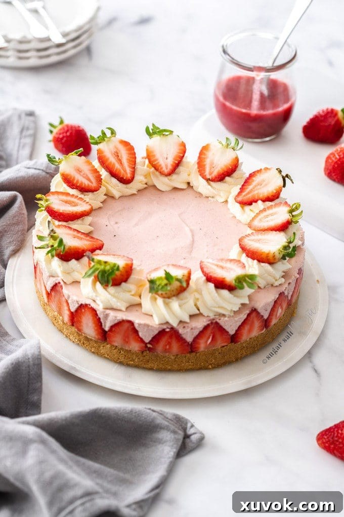 A pink cheesecake topped with strawberries on a marble background