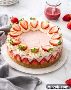 A pink cheesecake topped with strawberries on a marble background