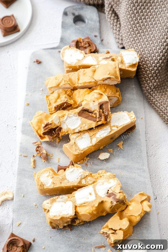 A beautifully arranged batch of golden Caramel White Chocolate Rocky Road Slices on a elegant marble board, showcasing their rich texture and ingredients.