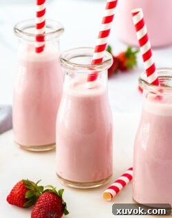 Closeup of a mini milk bottle filled with strawberry milk.
