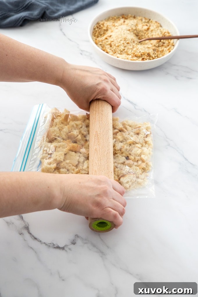 Someone rolling a rolling pin over a plastic bag filled with breadcrumbs.