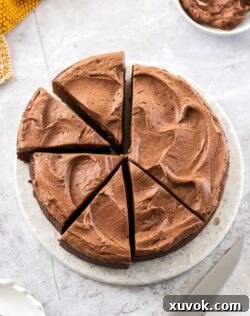 A chocolate mud cake cut into slices on a marble cake plate