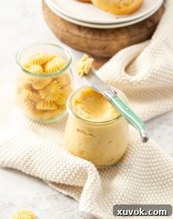 Two pots of maple butter sitting on white crocheted napkins, ready to be served