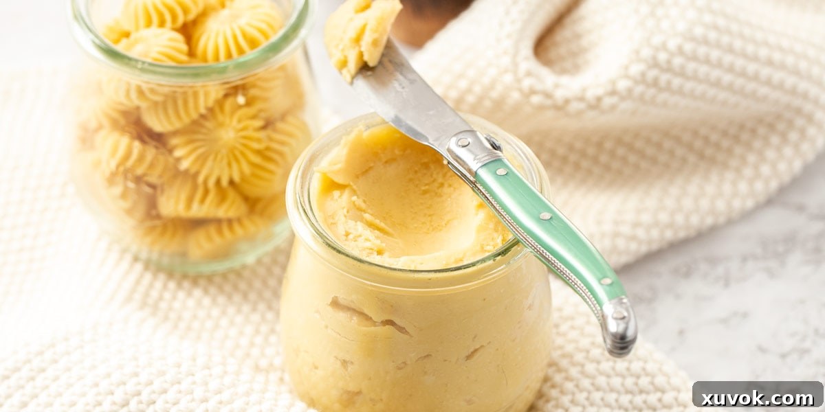 Two pots of maple butter sitting on white crocheted napkins. A green butter knife on one, reinforcing the inviting presentation and rich texture of the homemade spread.