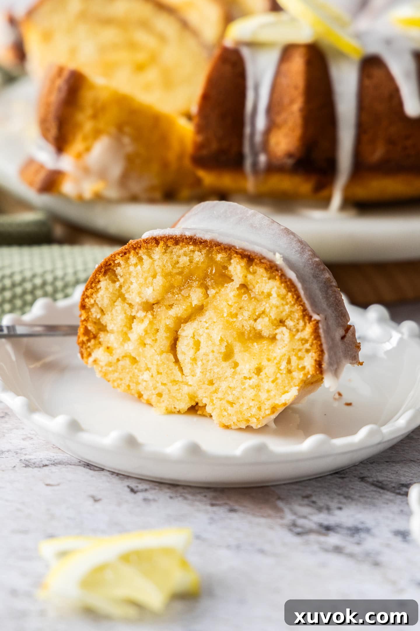 A perfectly sliced piece of lemon butter cake, revealing the delicious lemon curd swirl, elegantly presented on a dessert plate.