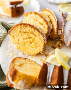 Closeup of the slices of lemon butter cake on a platter, highlighting the moist crumb and lemon curd swirl.