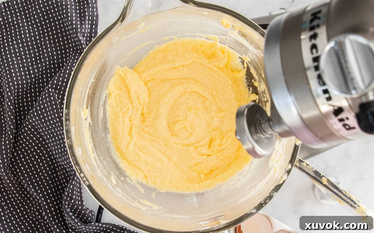 The cake batter showing a slightly split but normal consistency after the eggs have been added.