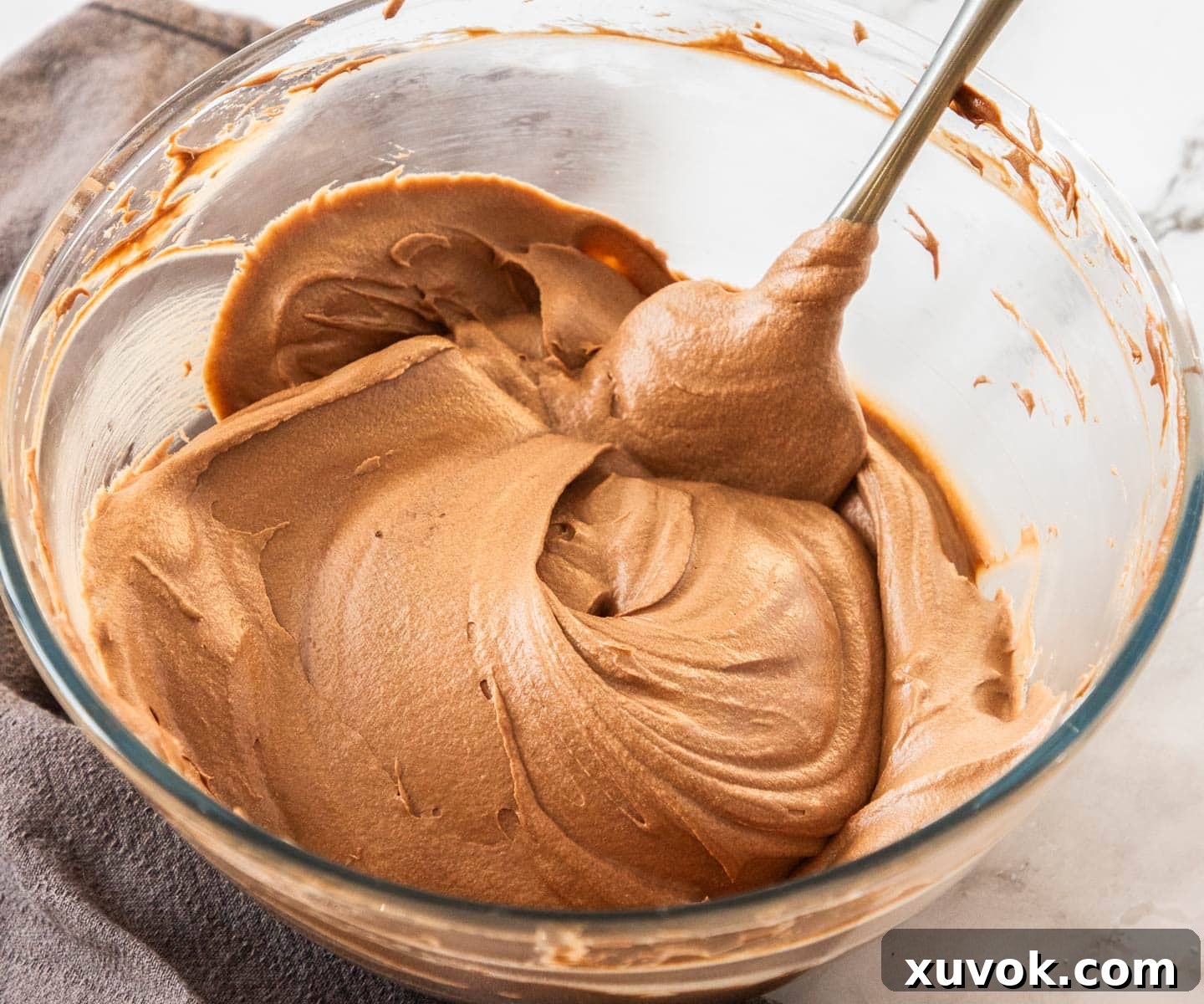 The mousse being gently folded in a bowl with a spatula.