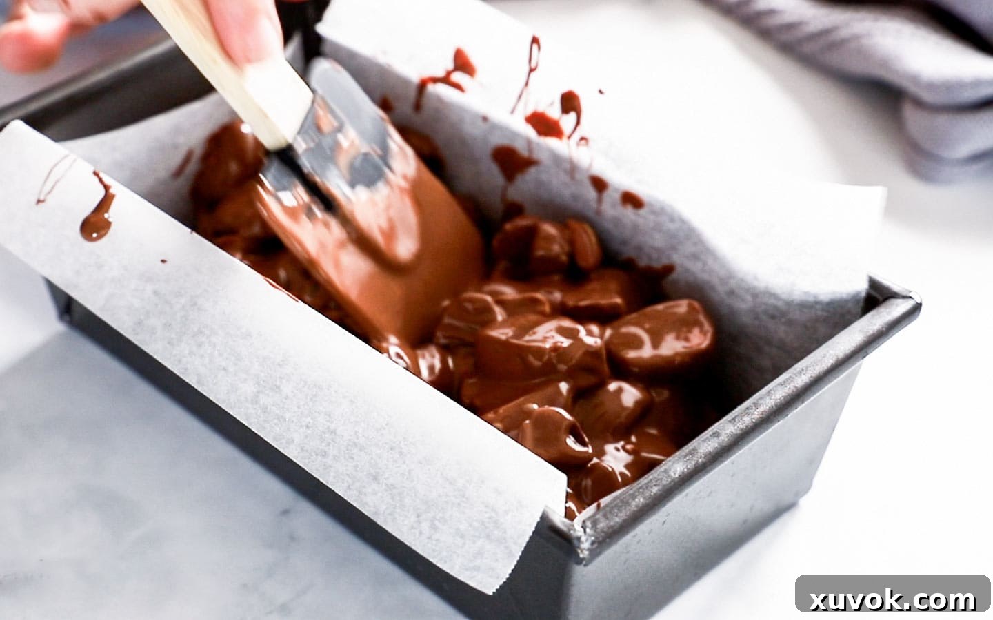 Levelling out rocky road in a loaf pan.