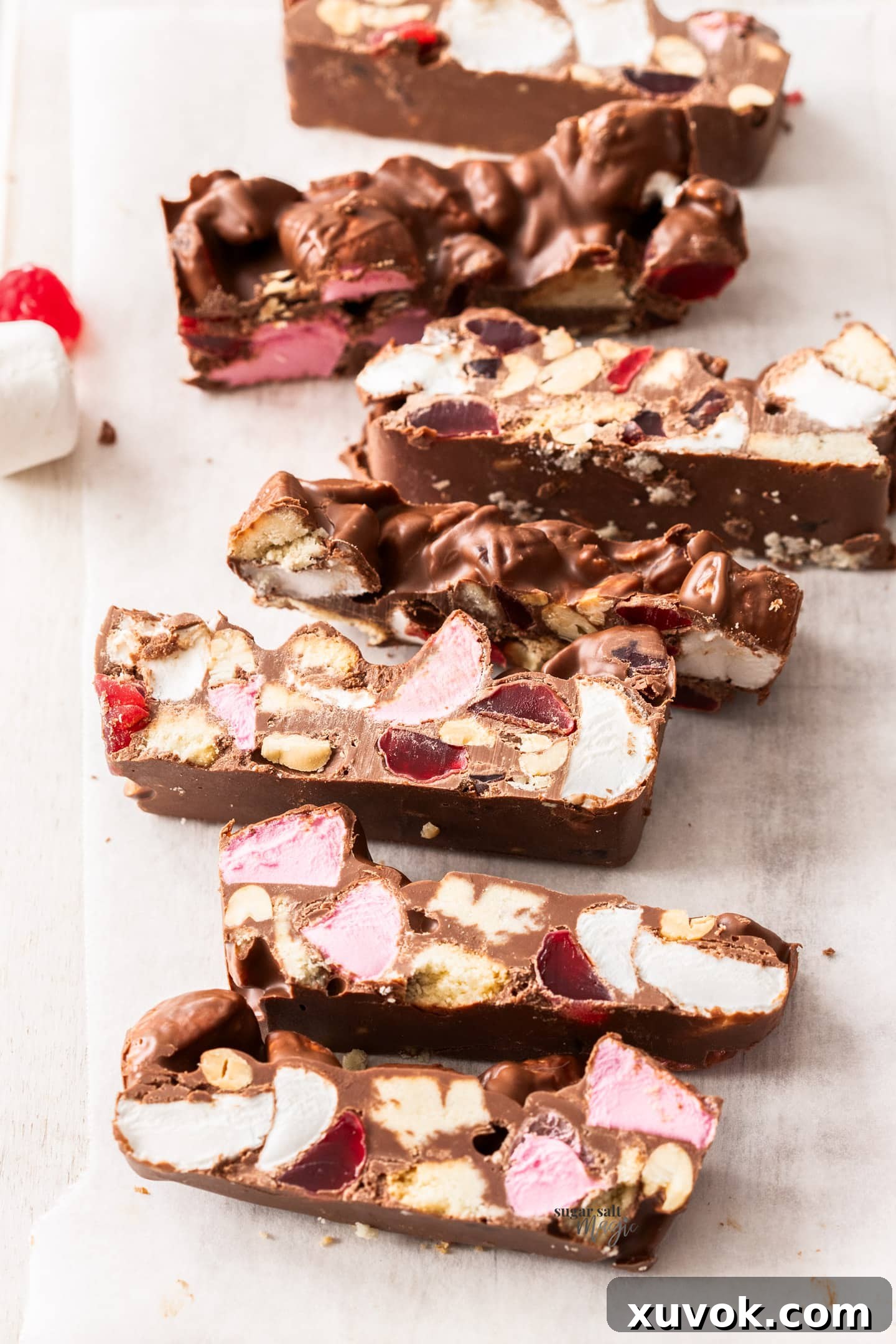 Beautifully arranged slices of homemade rocky road on a rustic wooden board, showcasing its rich textures and colors.