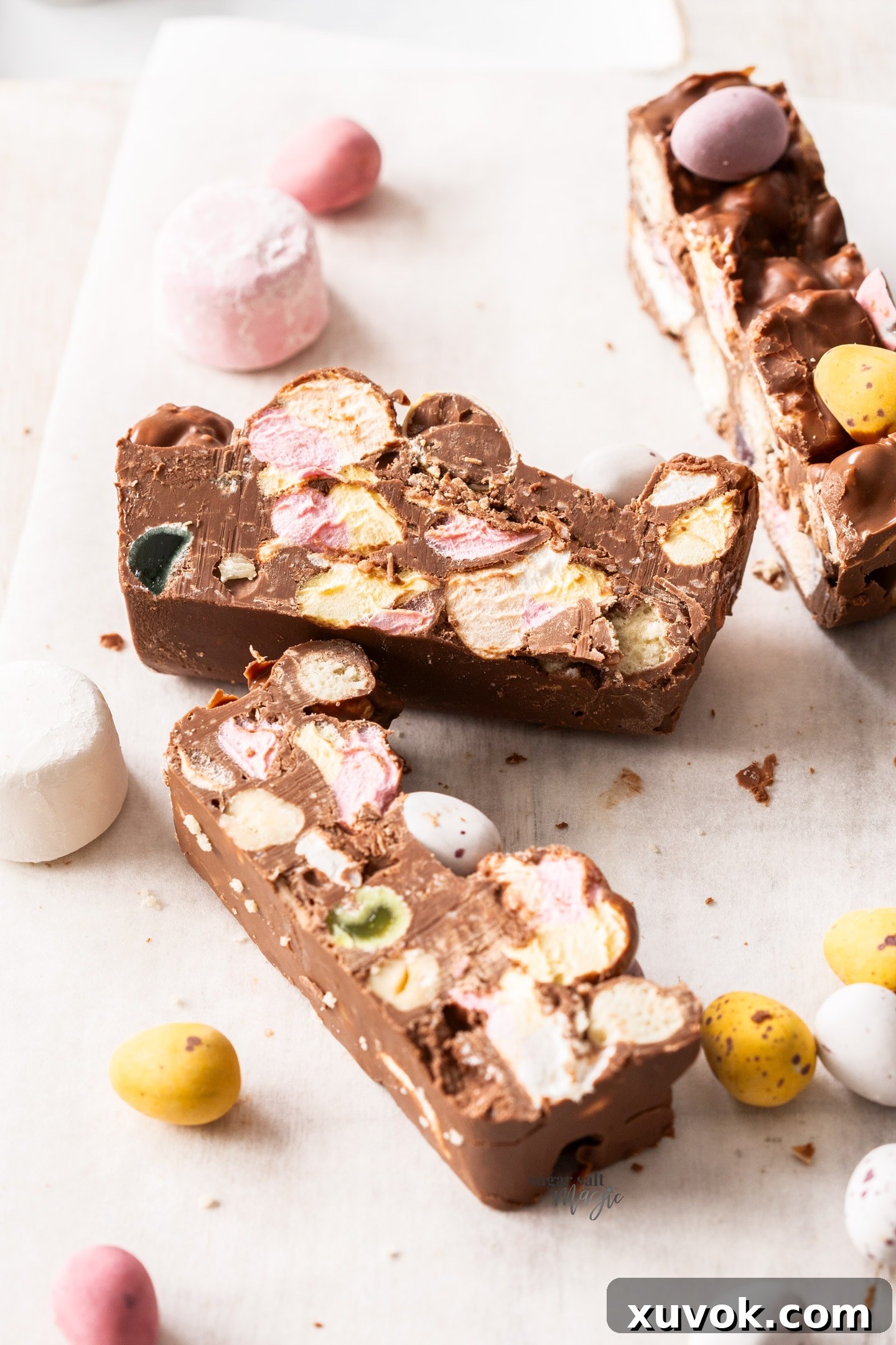 Three perfectly cut slices of Easter rocky road, adorned with colorful mini Easter eggs and festive candies.