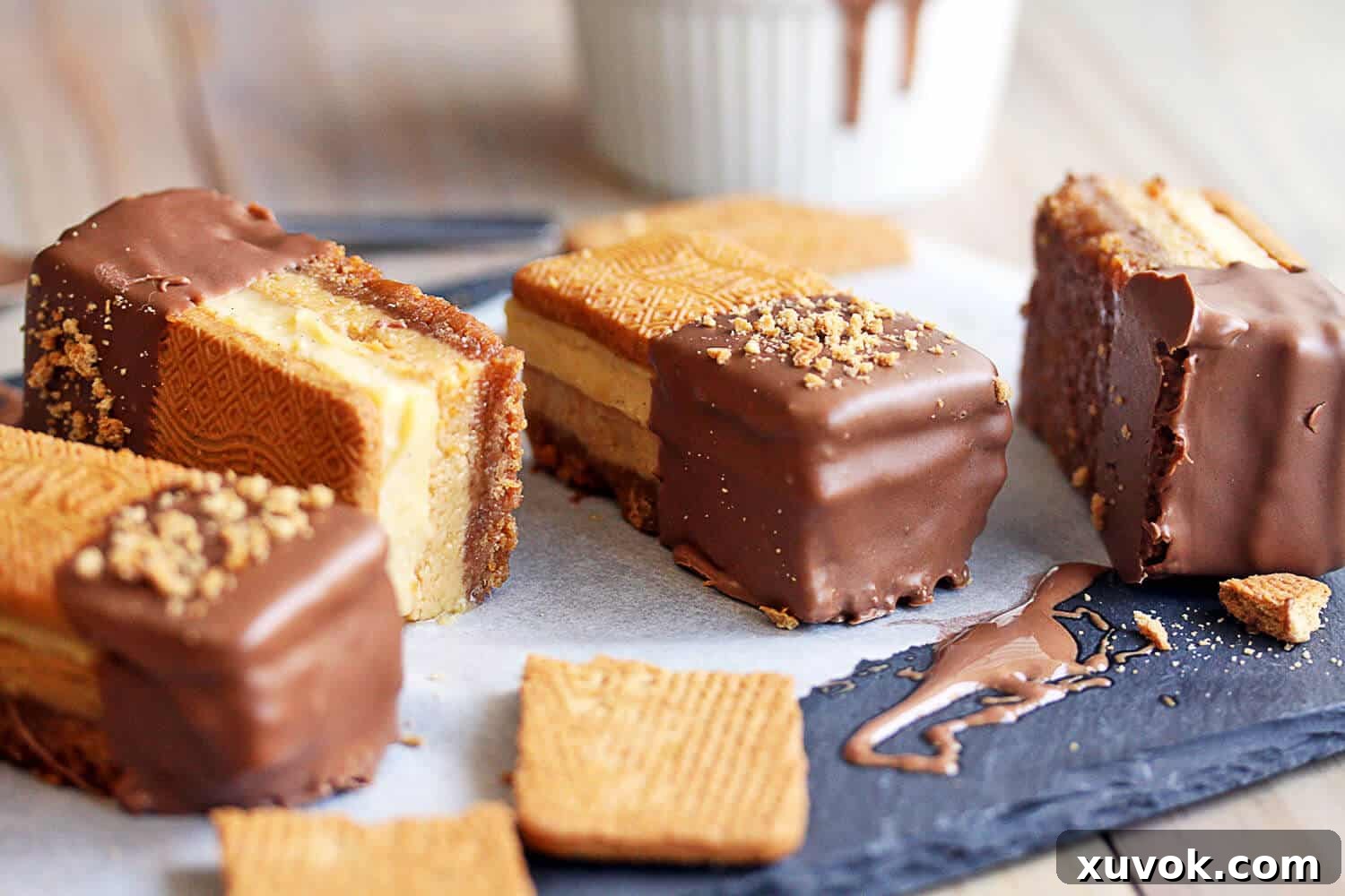 Four mouth-watering Golden Gaytime Slices arranged in a row, showcasing the even layering and generous chocolate and biscuit topping.