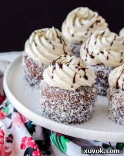 Lamington Cupcakes are those traditional little aussie cakes turned into a cupcake. A soft, fluffy vanilla cupcake, filled with jam and covered with an easy chocolate glaze and coconut.