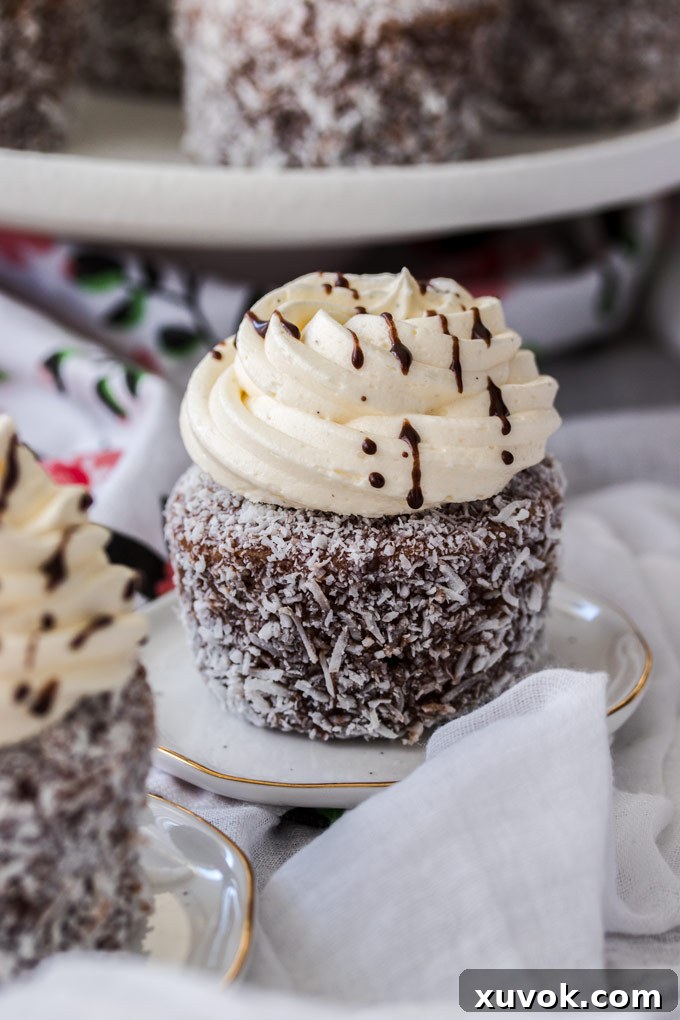A single Lamington cupcake on a mini dessert plate, showing its intricate details.
