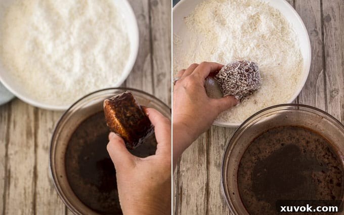 Two hands coating baked cupcakes in chocolate glaze and then rolling them in coconut.