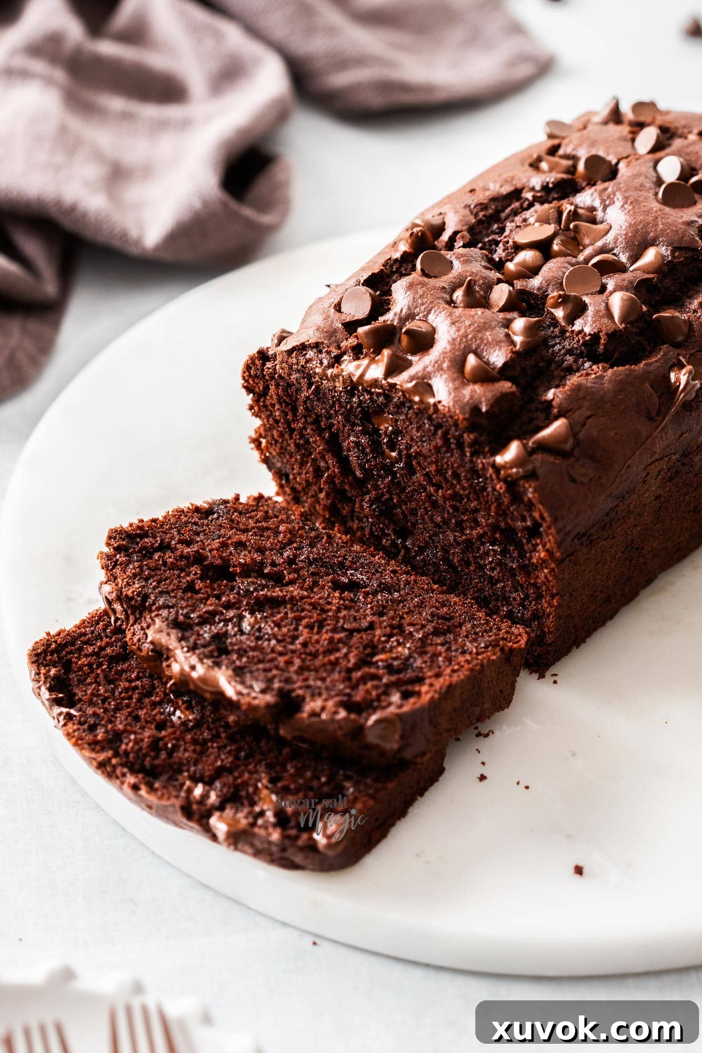 The sliced chocolate loaf cake on a marble platter, highlighting its moist texture and chocolate chips.