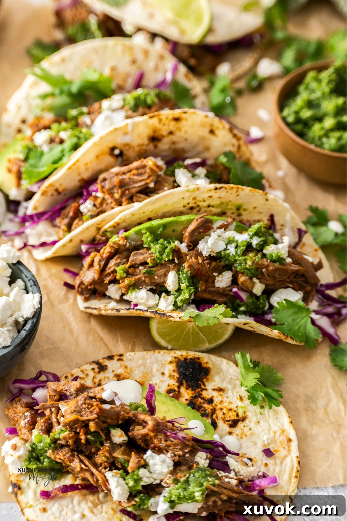 A batch of short rib tacos on sheet of parchment paper.