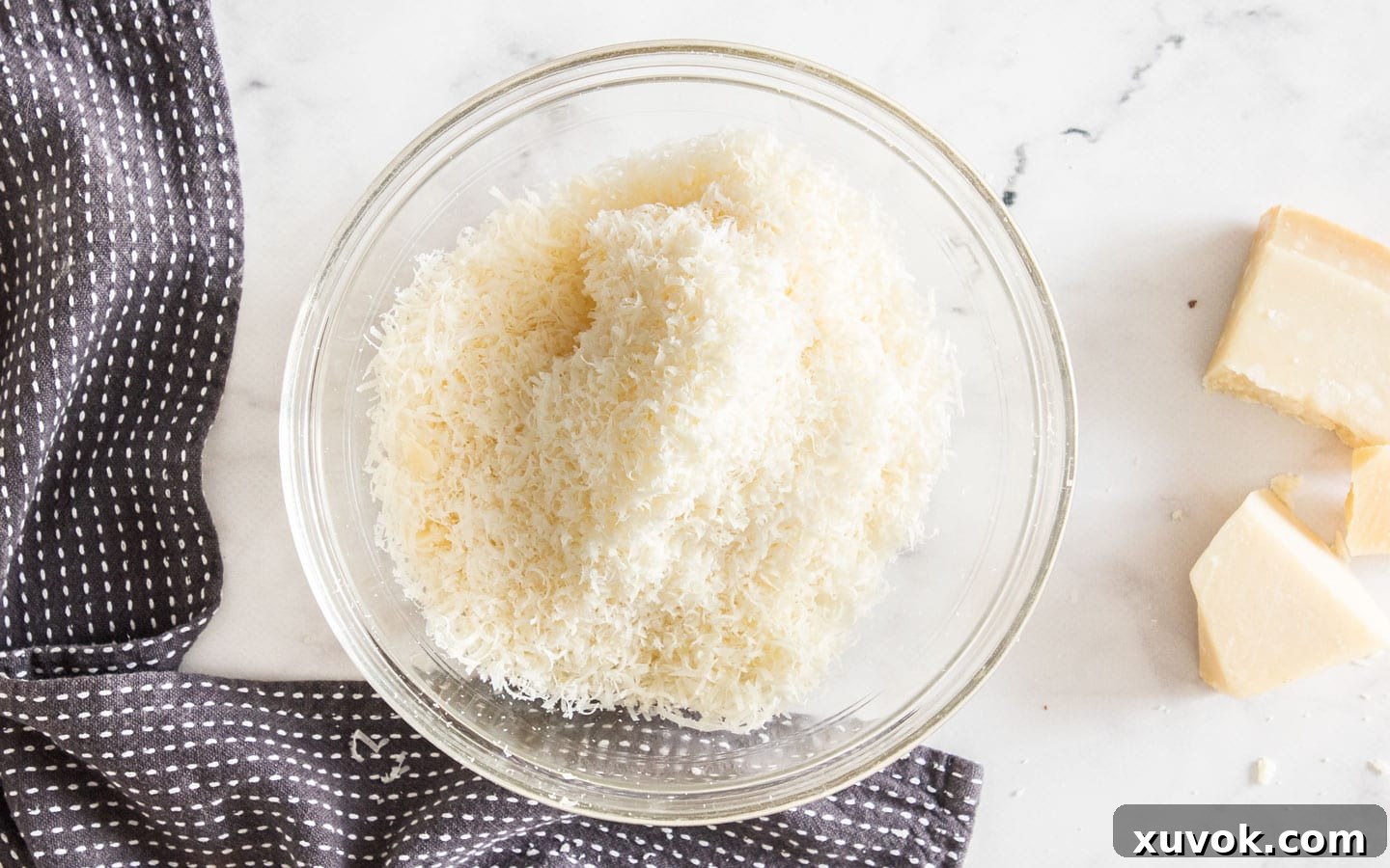 Finely grated parmesan cheese in a bowl, ready to be mixed with butter.