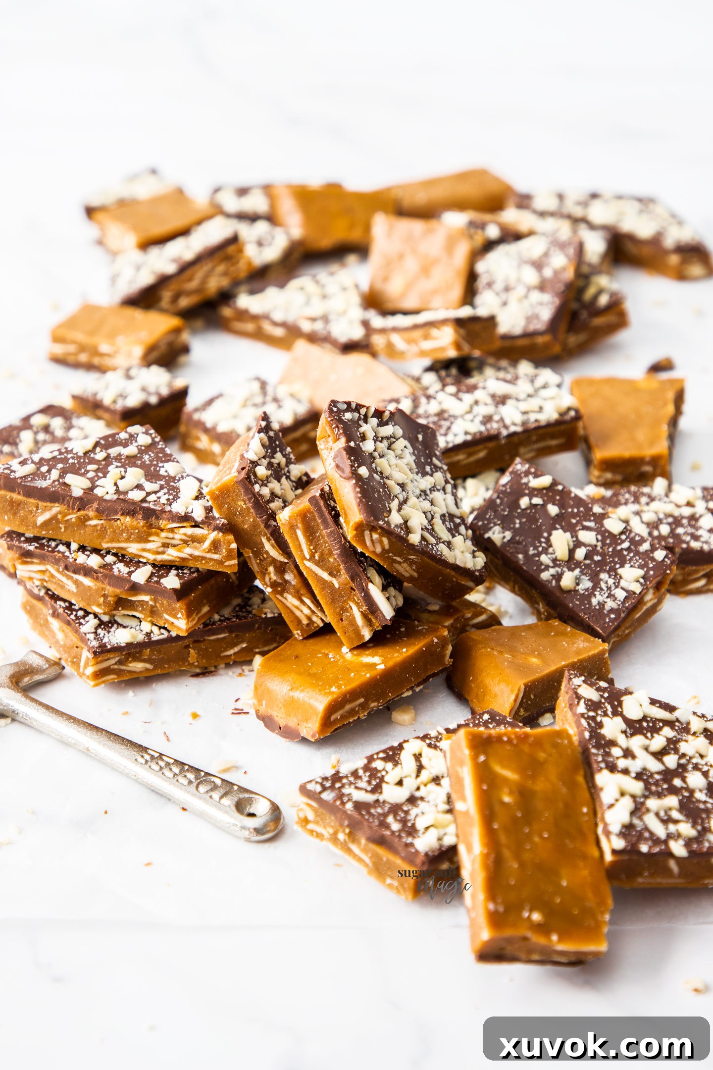 A charming pile of golden-brown buttercrunch toffee pieces, each distinct and covered in chocolate and almonds.