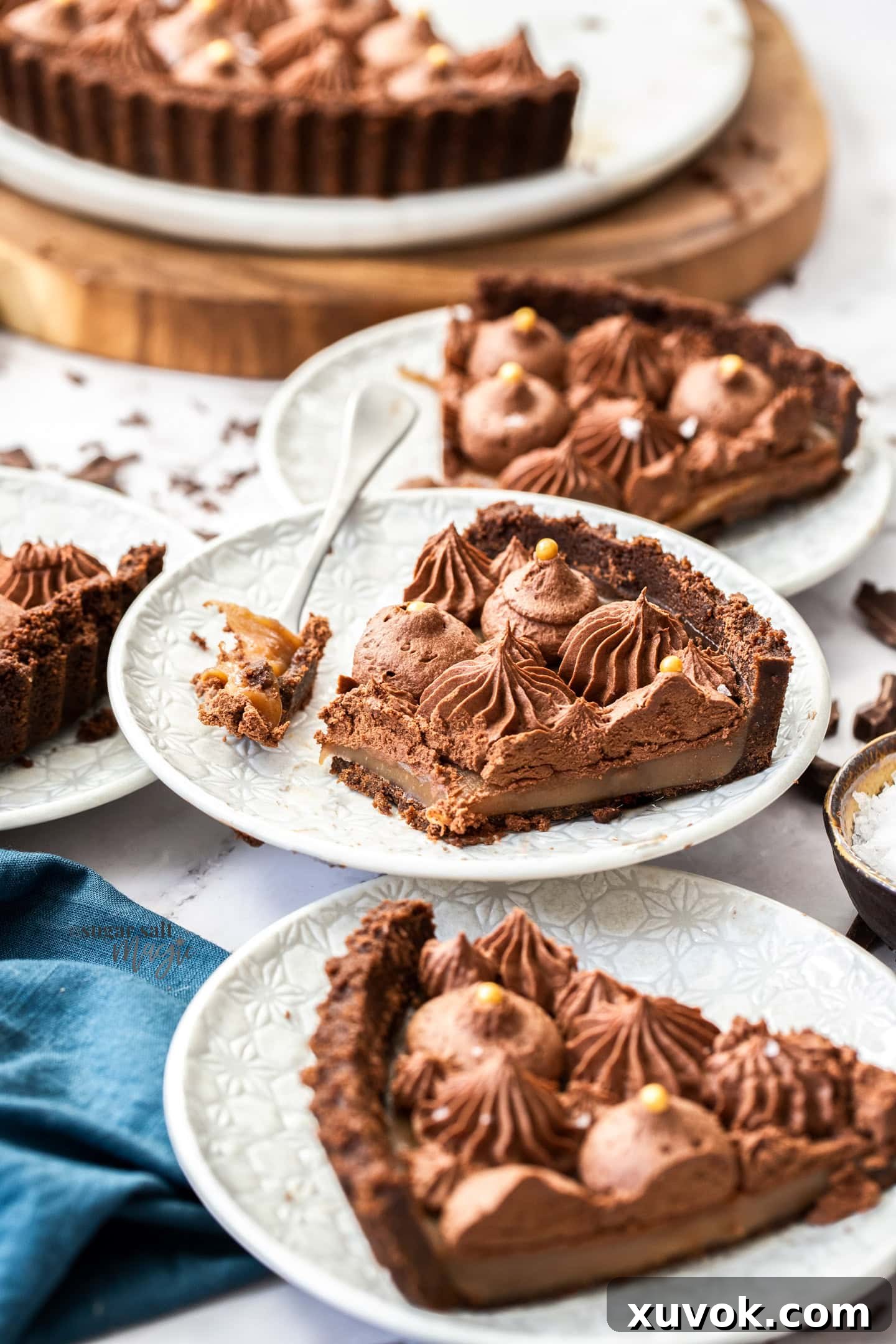A slice of chocolate caramel tart with a forkful cut away.