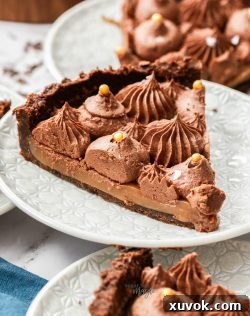 Closeup of a slice of caramel chocolate tart on a dessert plate.