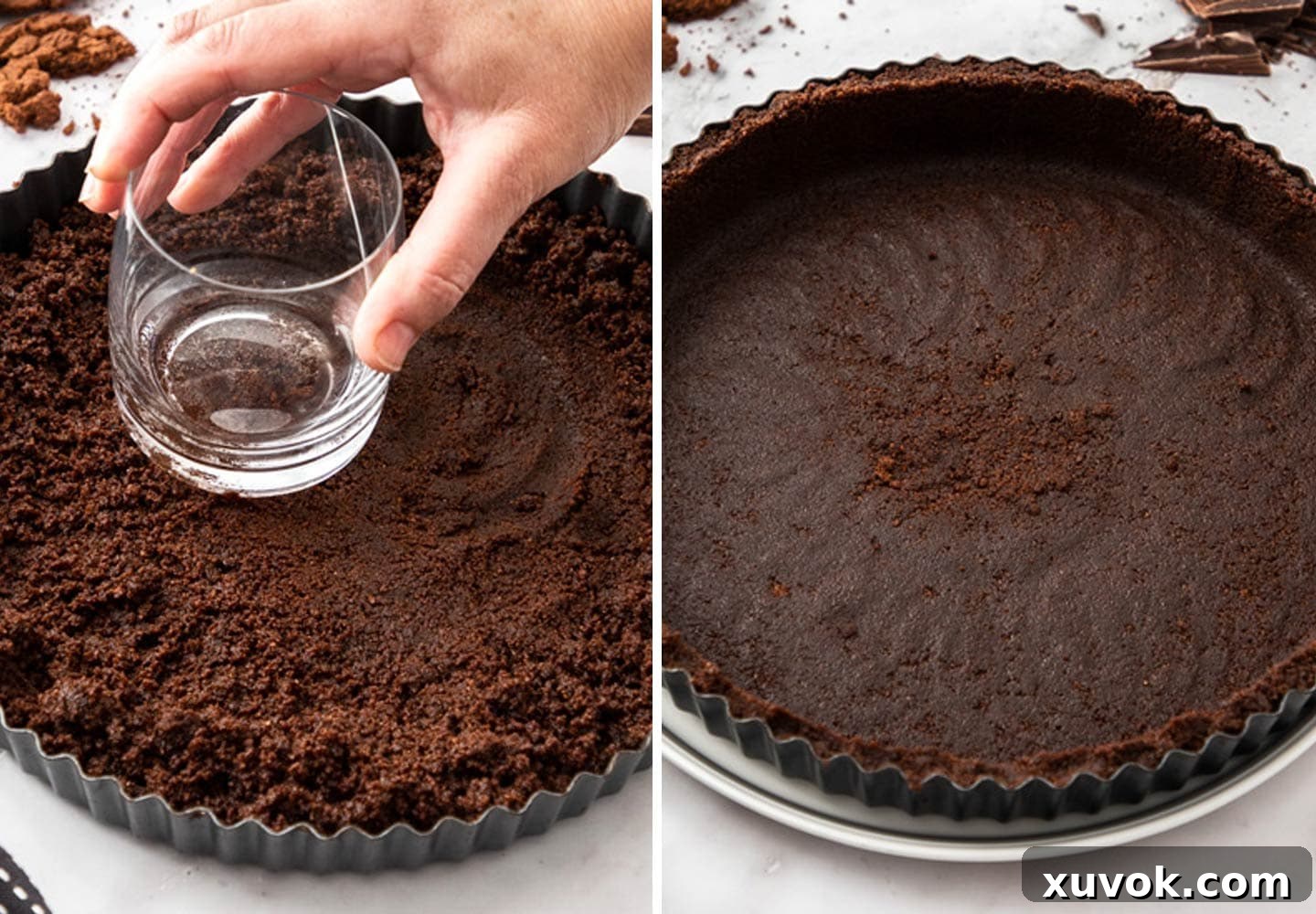 A hand using a glass to press cookie crumbs into a tart pan.