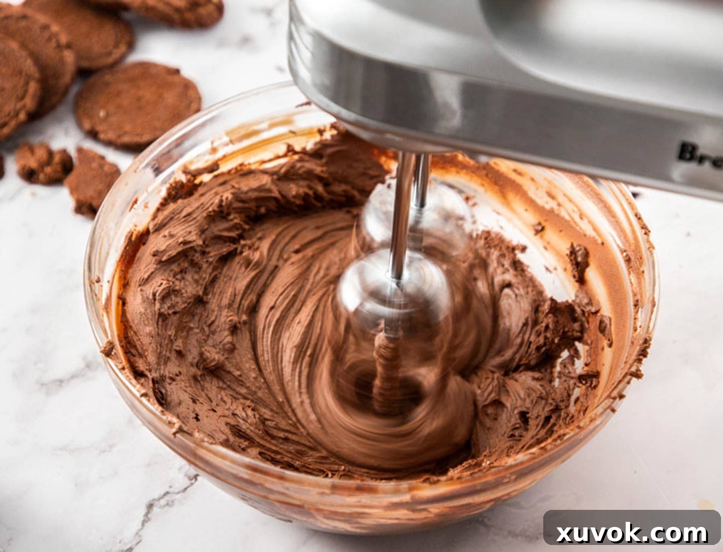 Chocolate ganache being whipped with an electric beater.