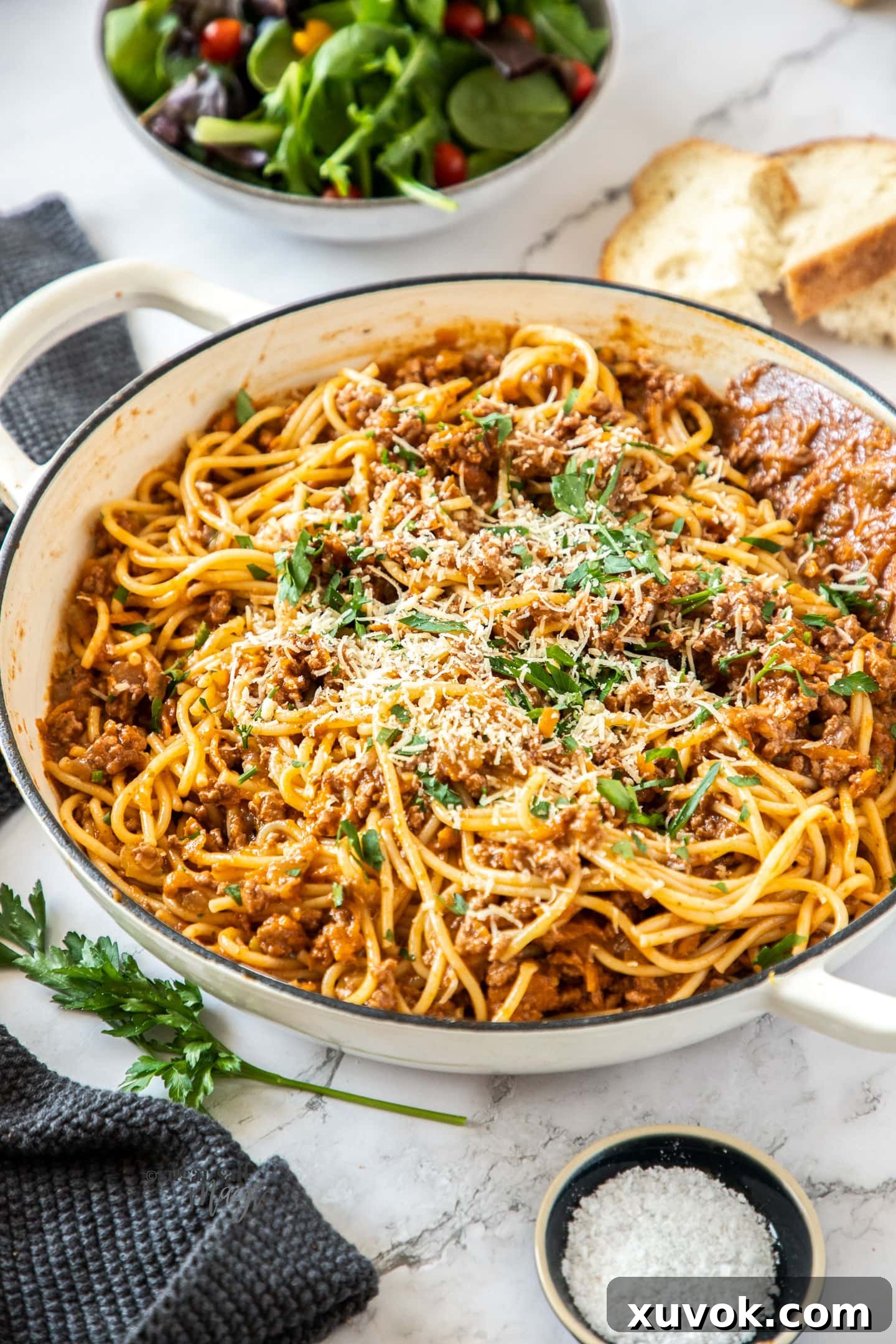 A white casserole dish filled with spaghetti bolognese.