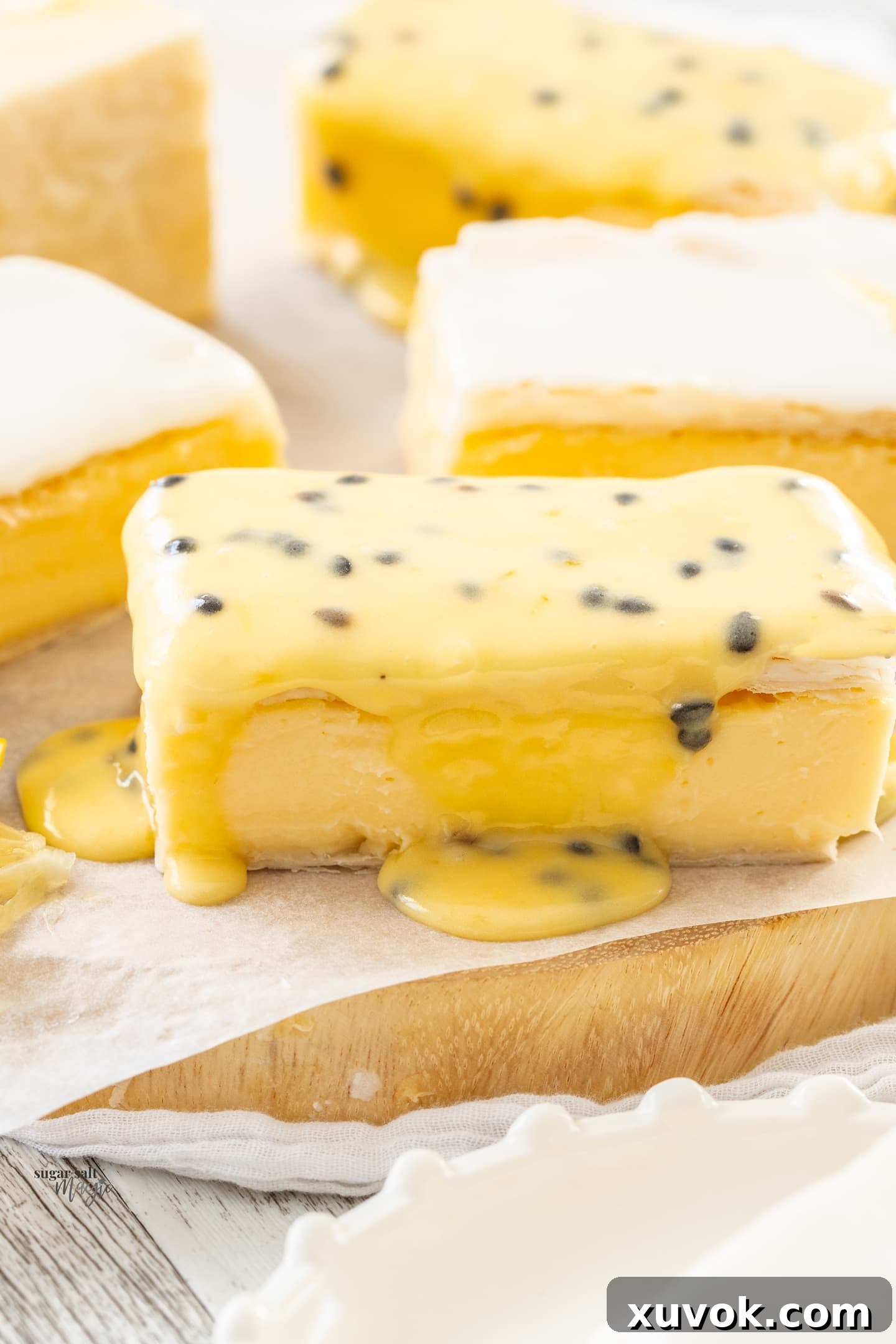 Closeup of a vanilla custard slice topped with passionfruit icing, showing the distinct layers.