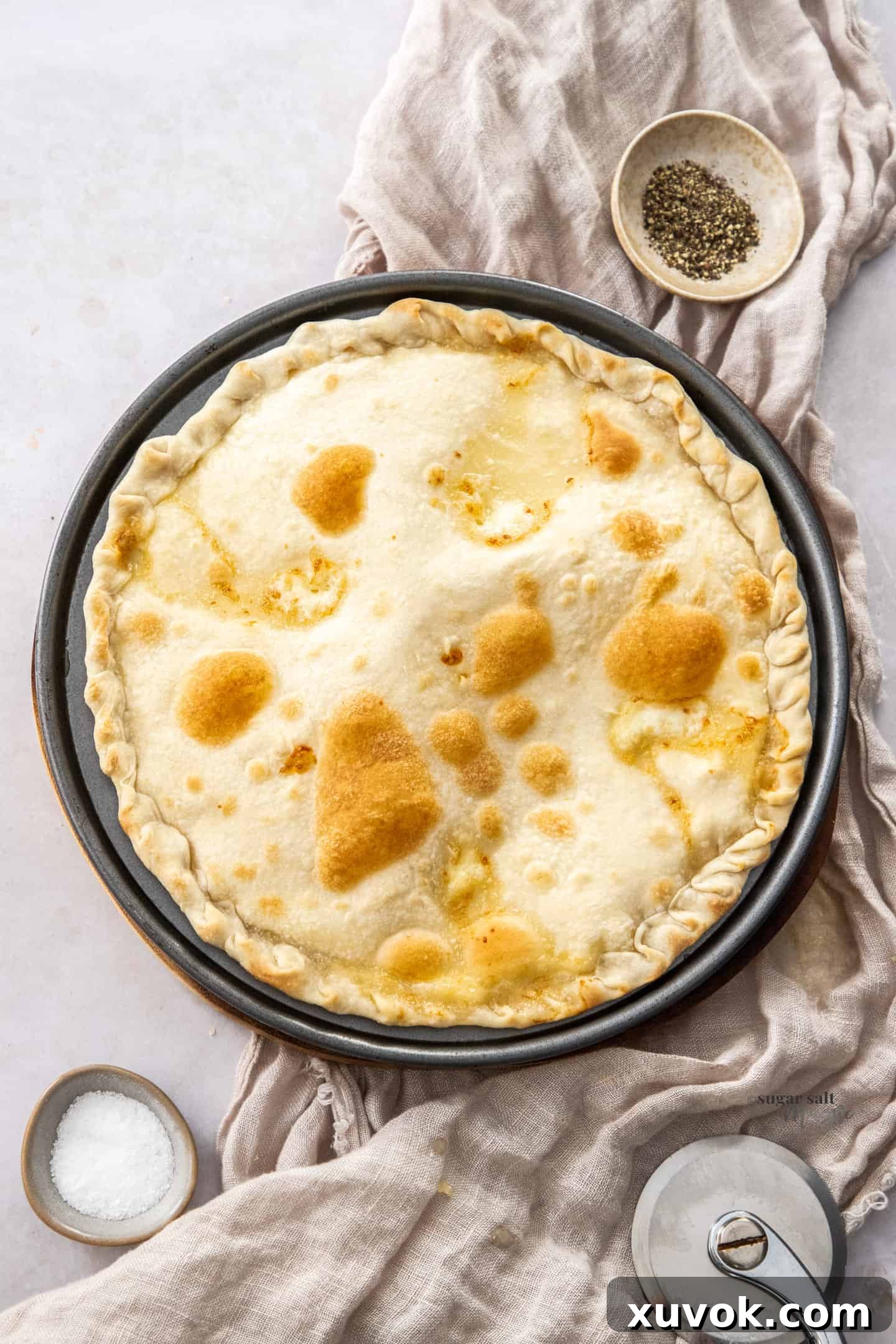 A whole focaccia di recco on a wooden board.