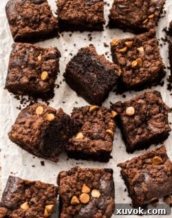 12 squares of chocolate crumb cake on a sheet of baking paper, perfectly baked and ready for serving or sharing.
