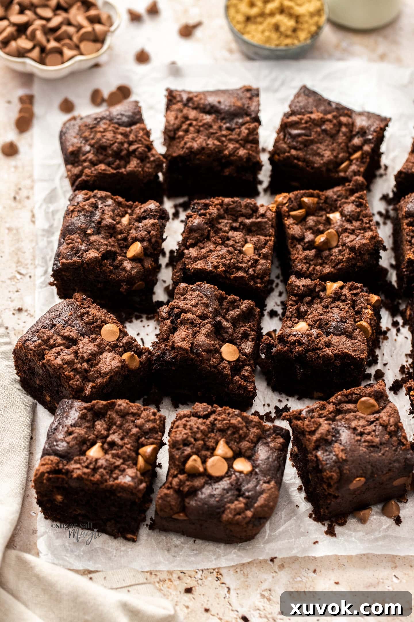 A chocolate crumb cake cut into neat squares on a sheet of baking paper, ready to be served or stored.