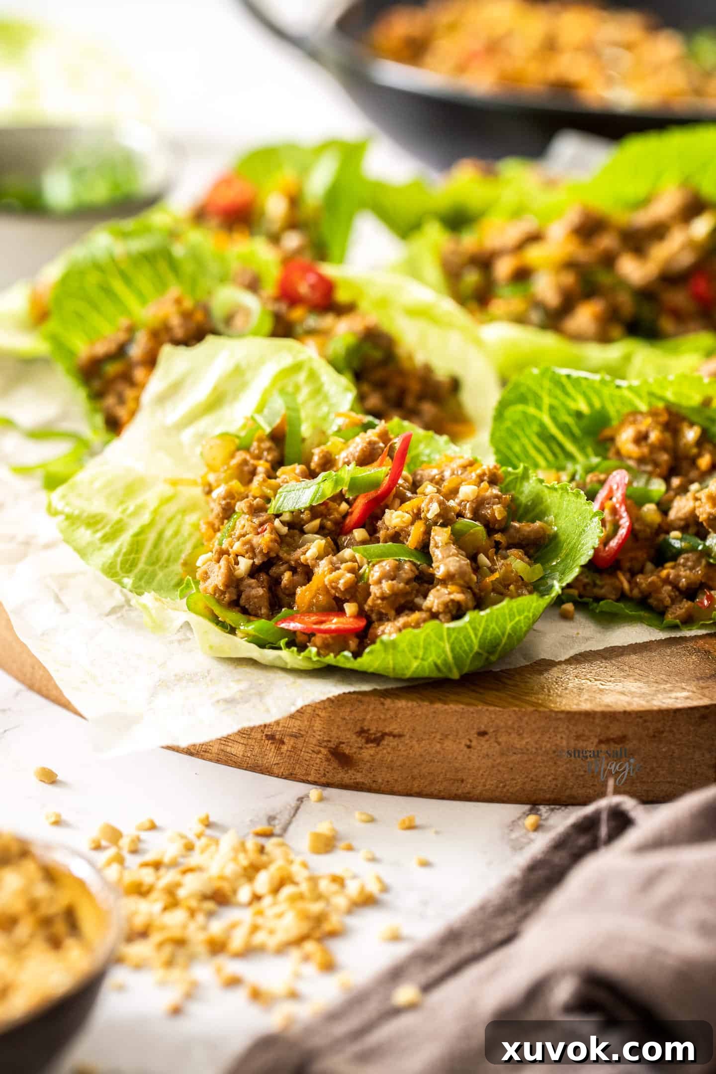 A single, perfectly formed lettuce leaf cradling a generous portion of the flavorful san choy bow meat filling, ready for a bite.