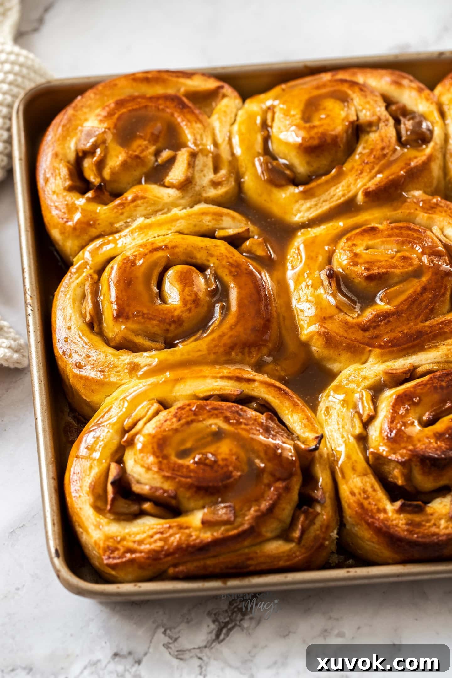 A gold baking tray filled with cinnamon rolls.