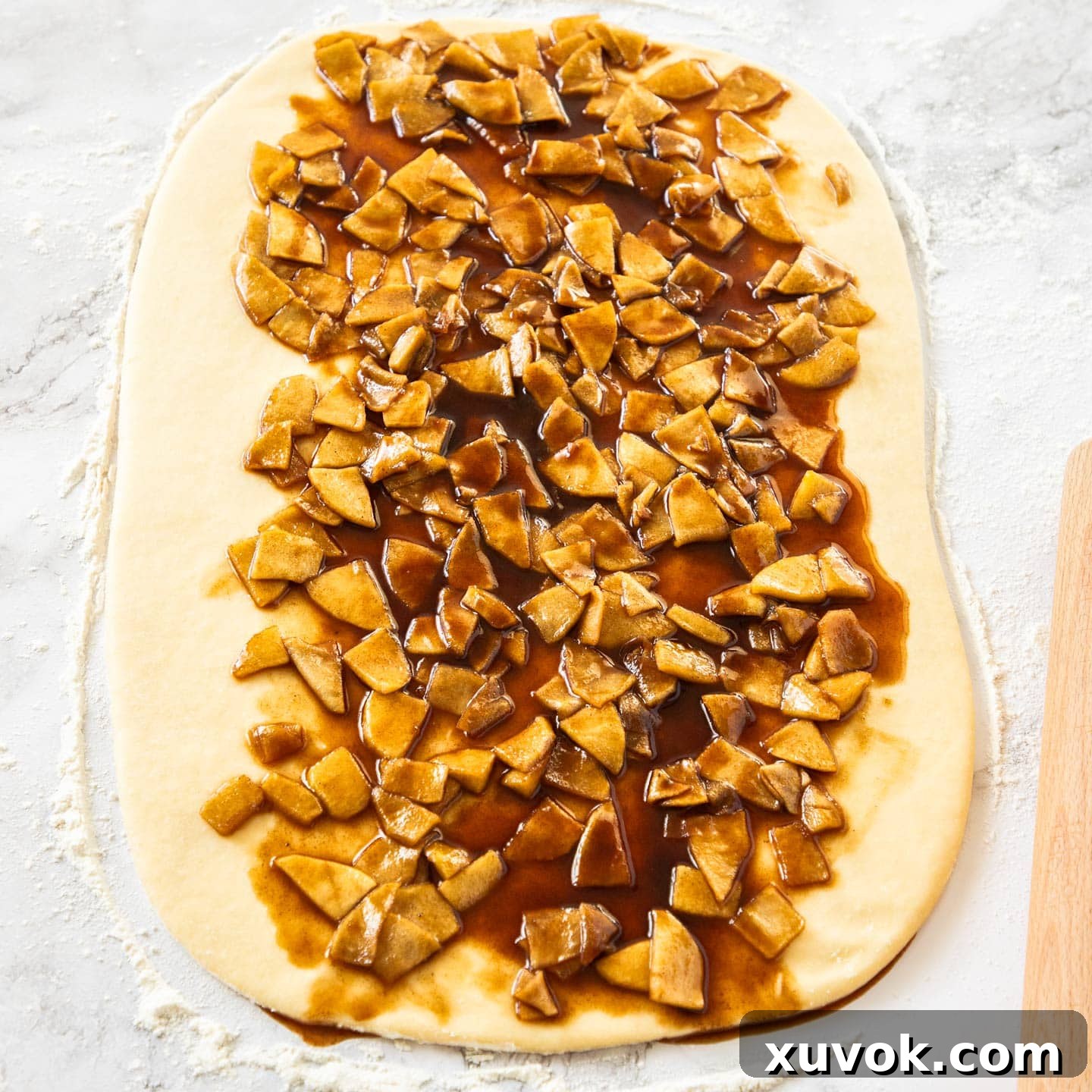 The caramel apple filling spread out on the rolled out dough.