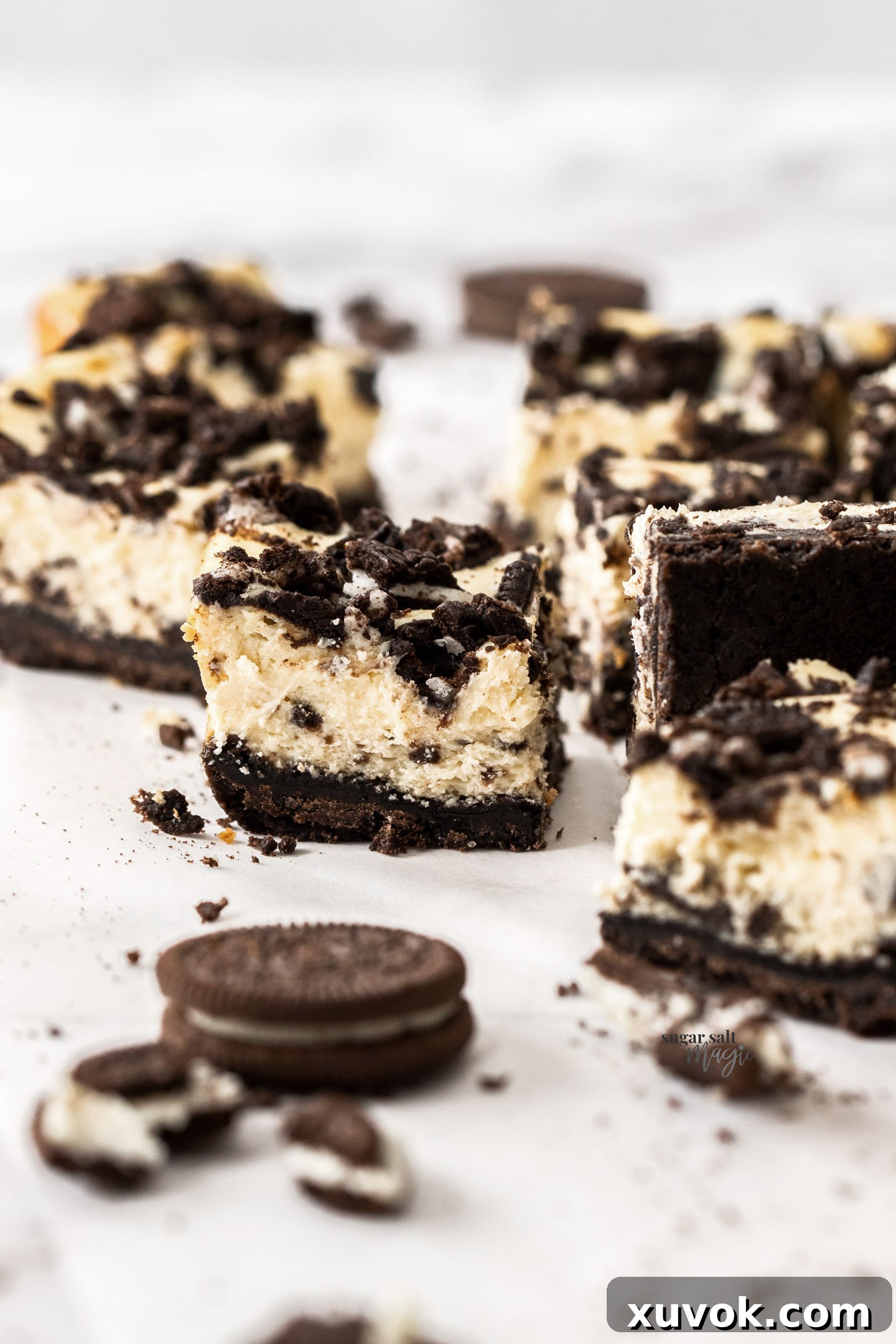A close-up view of the cross-section of an Oreo cheesecake bar, revealing its perfectly layered creamy texture and crunchy Oreo pieces.