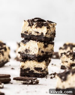 Three perfectly stacked Oreo cheesecake bars, showcasing the rich layers of crust, creamy filling, and cookie topping.