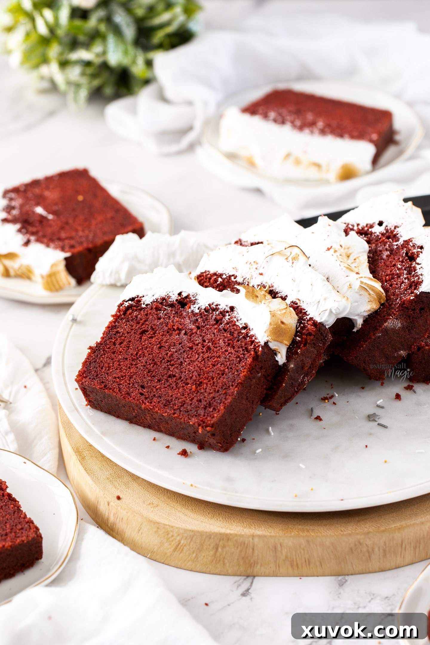 Delightful slices of Red Velvet Pound Cake with fluffy marshmallow frosting on a pristine white platter, ready to be enjoyed.