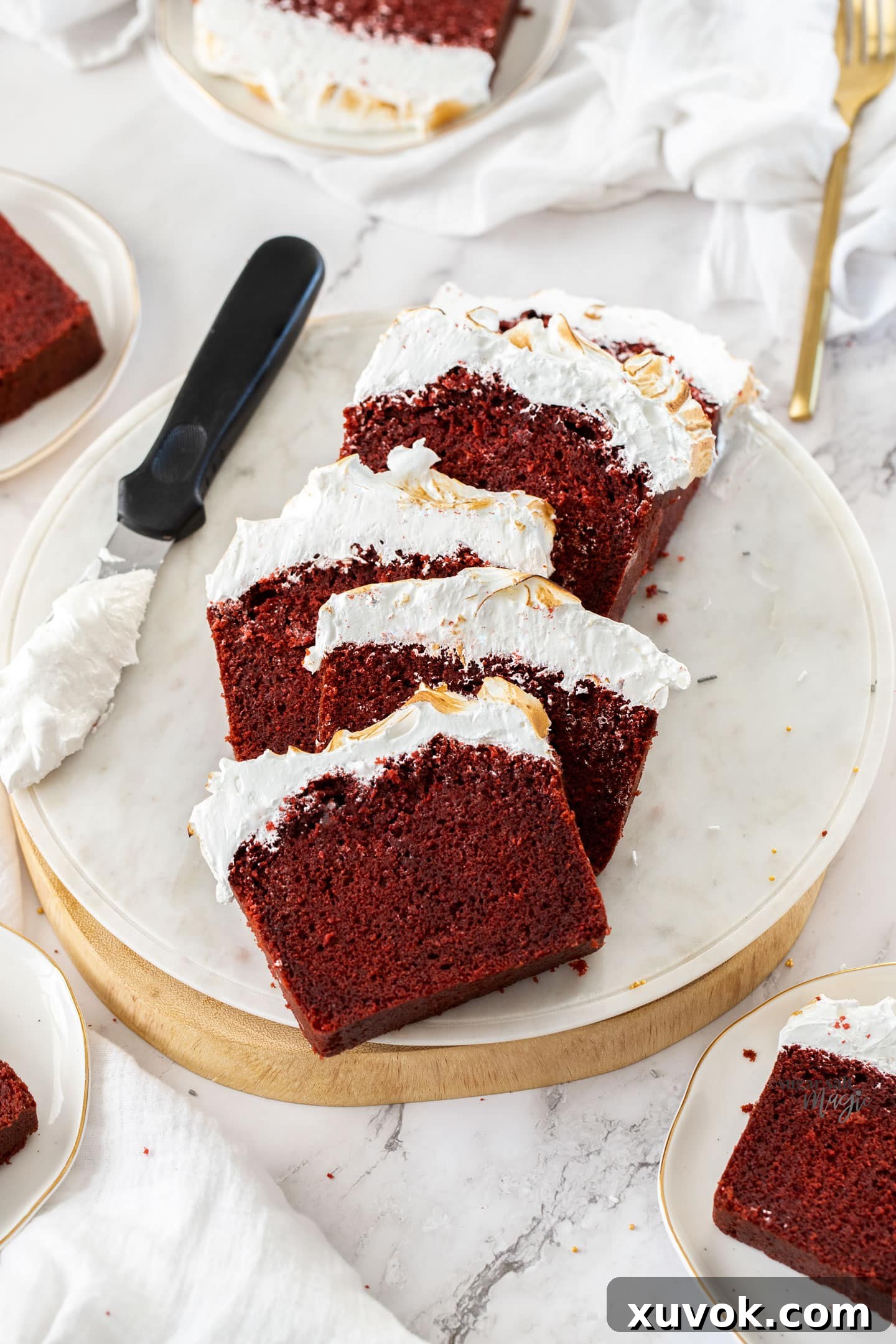 Beautifully presented slices of Red Velvet Pound Cake adorned with toasted marshmallow frosting on a clean white platter, ready for dessert.