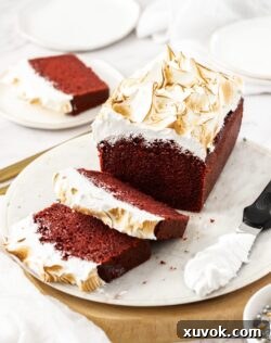 A beautifully presented Red Velvet Pound Cake on a white platter with two perfectly cut slices ready to serve.