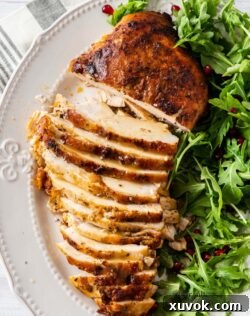 A golden turkey breast on a plate, partly sliced, with green salad on the side.